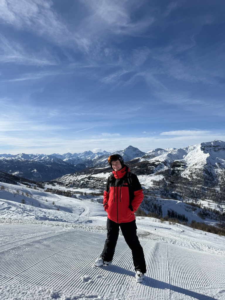 Ed on a groomed ski slope with mountain views